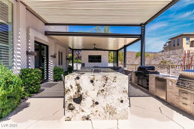 view of patio / terrace with area for grilling, a grill, fence, and a mountain view