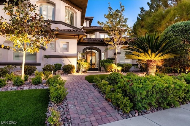 doorway to property featuring stucco siding and a tiled roof