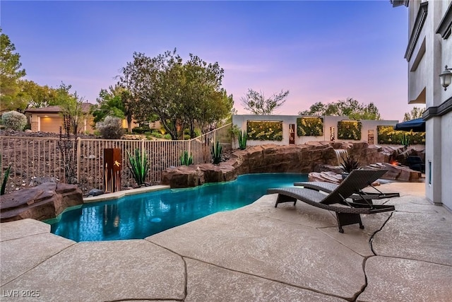 pool at dusk featuring a patio and fence