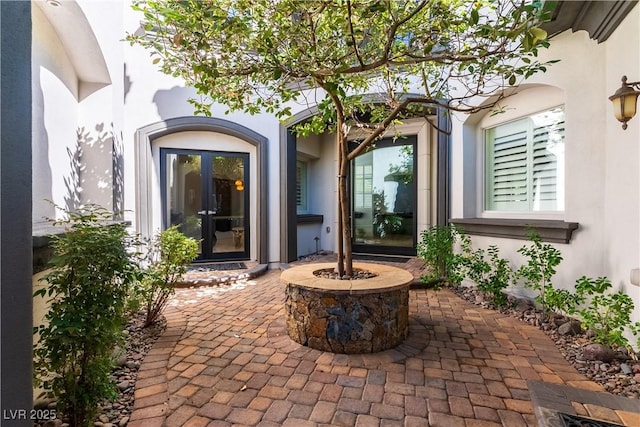 doorway to property featuring stucco siding and a patio area