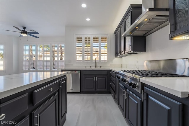 1316 Eagle Meadow Ct, Las Vegas, NV 89123 - kitchen with stainless steel appliances, a sink, wall chimney range hood, ceiling fan, and recessed lighting