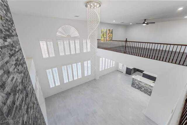 1316 Eagle Meadow Ct, Las Vegas, NV 89123 - unfurnished living room featuring a ceiling fan, a chandelier, a high ceiling, and recessed lighting