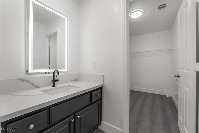 1316 Eagle Meadow Ct, Las Vegas, NV 89123 - bathroom with a spacious closet, vanity, wood finished floors, and baseboards