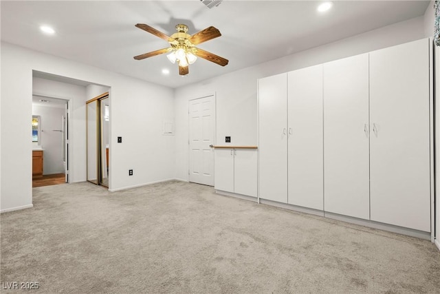 unfurnished bedroom with recessed lighting, light carpet, baseboards, ensuite bathroom, and ceiling fan