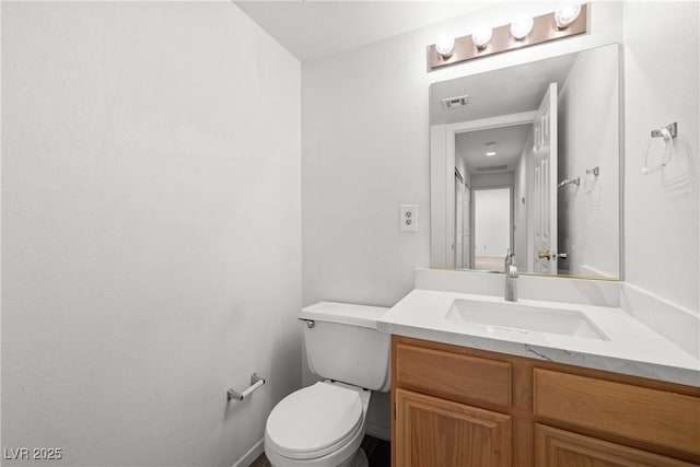 half bath featuring vanity and toilet