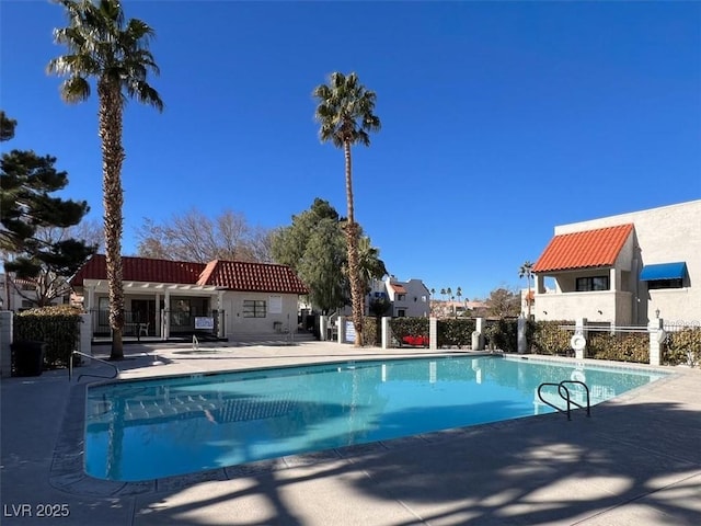 community pool featuring a patio and fence