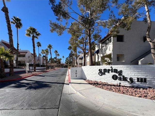 view of asphalt street with sidewalks, a residential view, and curbs