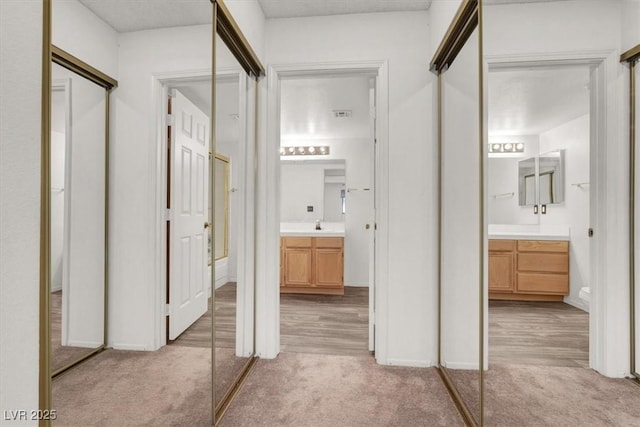 bathroom featuring vanity, carpet floors, and baseboards