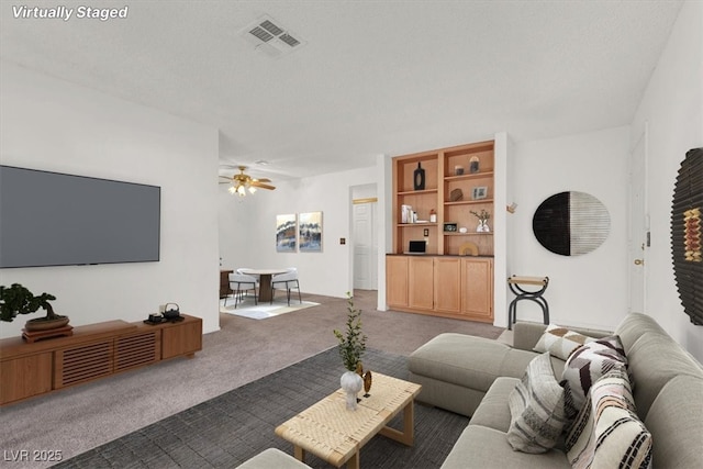 carpeted living area featuring ceiling fan