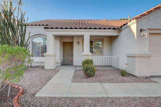 832 Seco Verde Ave, Henderson, NV 89015 - doorway to property with covered porch, stucco siding, a tiled roof, and a garage