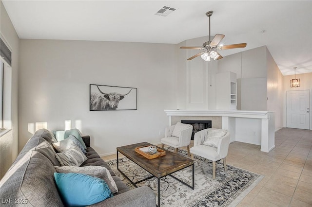 832 Seco Verde Ave, Henderson, NV 89015 - living room with a ceiling fan, light tile patterned flooring, a glass covered fireplace, high vaulted ceiling, and baseboards