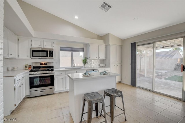 832 Seco Verde Ave, Henderson, NV 89015 - kitchen featuring appliances with stainless steel finishes, lofted ceiling, a sink, light countertops, and white cabinets