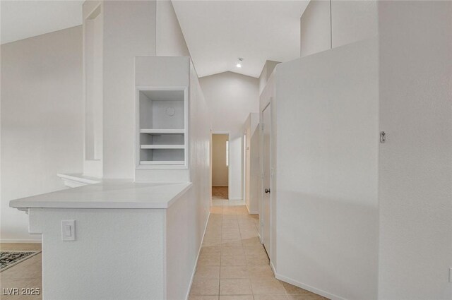 832 Seco Verde Ave, Henderson, NV 89015 - hallway featuring light tile patterned floors, built in shelves, lofted ceiling, and baseboards