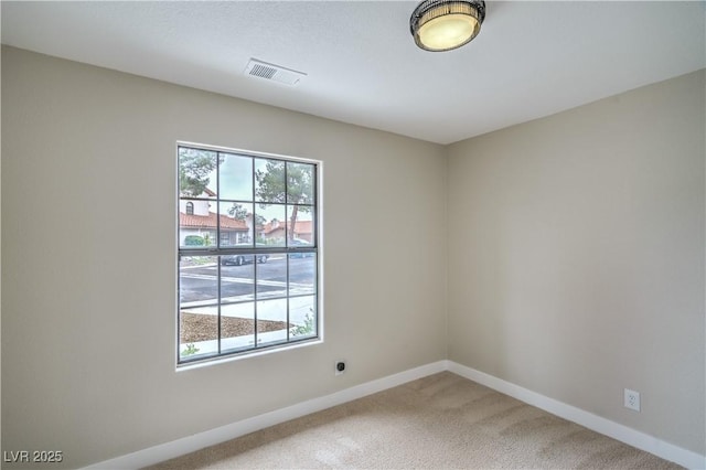 carpeted spare room featuring baseboards