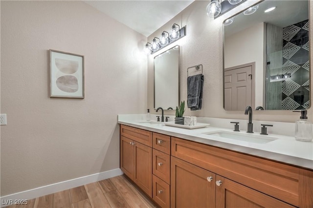 full bathroom with baseboards, wood finished floors, and double vanity