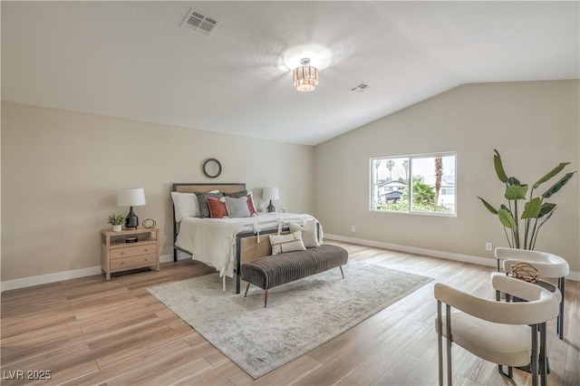 bedroom with vaulted ceiling, baseboards, and light wood-style floors
