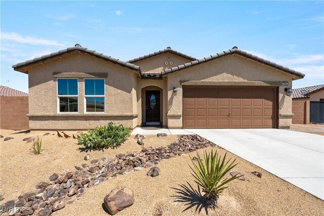 3966 E Garfield Dr, Pahrump, NV 89061 - view of front facade featuring stucco siding, an attached garage, driveway, a tile roof, and fence