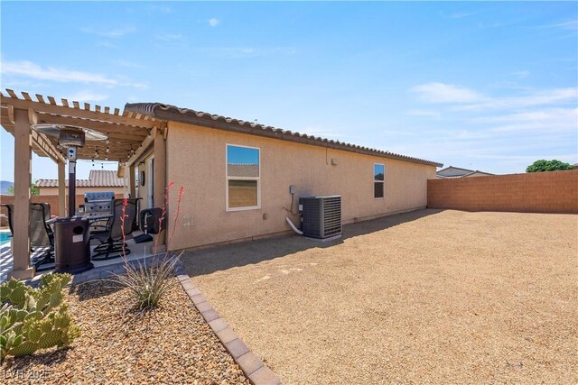 3966 E Garfield Dr, Pahrump, NV 89061 - rear view of house with central air condition unit, a fenced backyard, a pergola, stucco siding, and a patio area