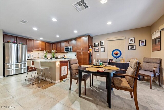 3966 E Garfield Dr, Pahrump, NV 89061 - kitchen featuring appliances with stainless steel finishes, a center island, a kitchen breakfast bar, recessed lighting, and light tile patterned flooring