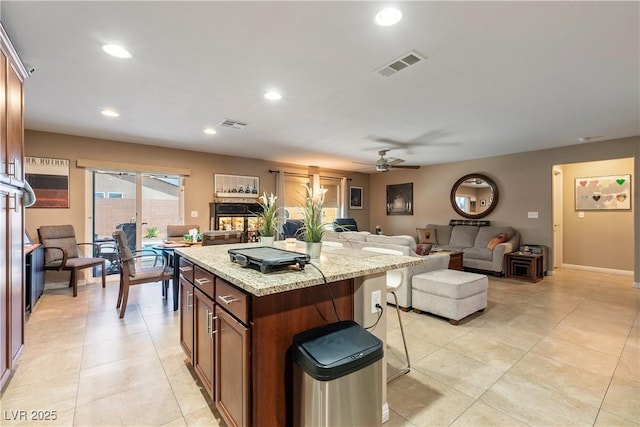 3966 E Garfield Dr, Pahrump, NV 89061 - kitchen featuring a kitchen island, recessed lighting, a ceiling fan, light stone countertops, and light tile patterned flooring