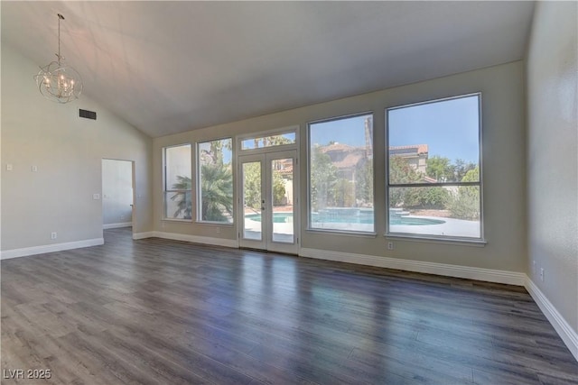 8300 Slate Harbor Cir, Las Vegas, NV 89128 - unfurnished living room featuring a chandelier, french doors, dark wood-style flooring, lofted ceiling, and baseboards