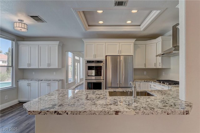 8300 Slate Harbor Cir, Las Vegas, NV 89128 - kitchen with appliances with stainless steel finishes, a sink, wall chimney range hood, white cabinetry, and crown molding