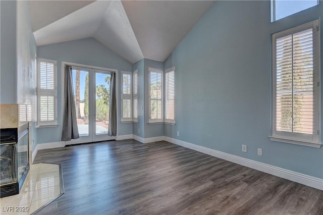 8300 Slate Harbor Cir, Las Vegas, NV 89128 - unfurnished living room with dark wood finished floors, baseboards, lofted ceiling, and a premium fireplace