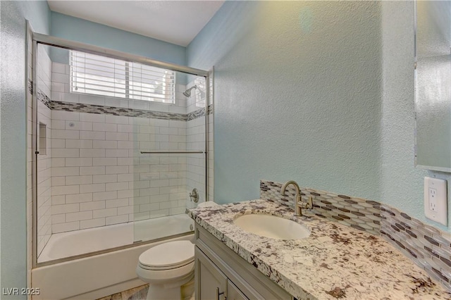 8300 Slate Harbor Cir, Las Vegas, NV 89128 - bathroom with a textured wall, toilet, vanity, and shower / bath combination with glass door