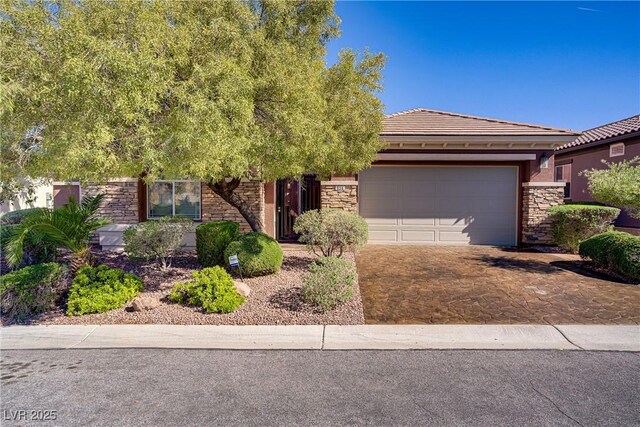 936 Viscanio Pl, Las Vegas, NV 89138 - view of front of home featuring stone siding, an attached garage, a tiled roof, driveway, and stucco siding