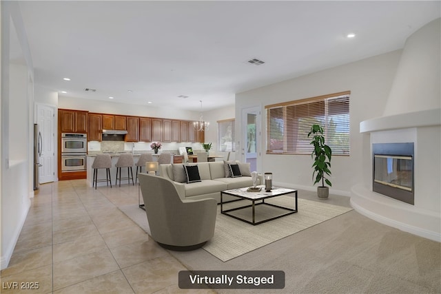 living area with recessed lighting, a fireplace, a chandelier, baseboards, and light tile patterned floors
