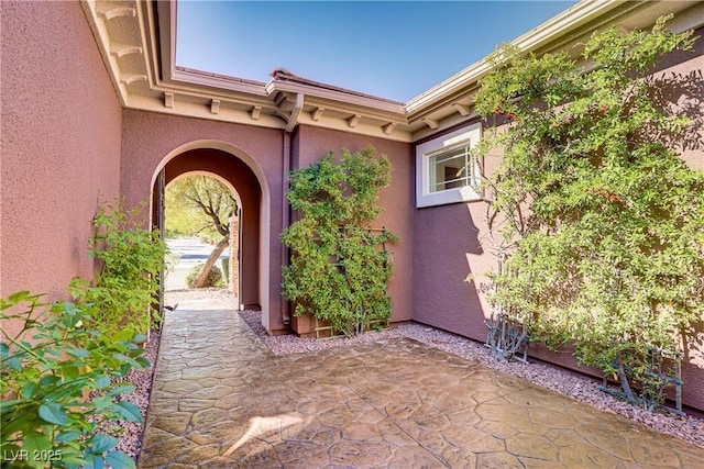 property entrance featuring a patio and stucco siding