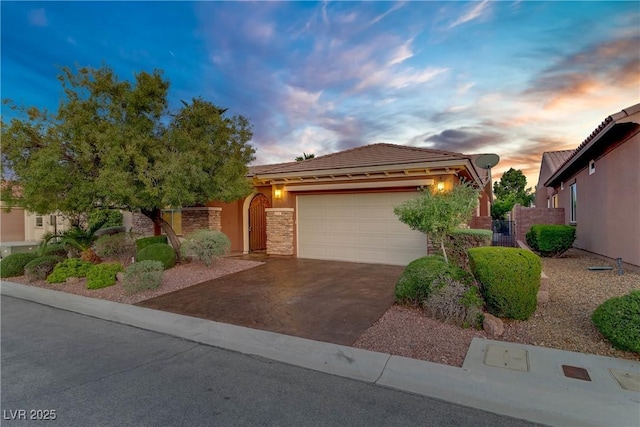 view of front of home featuring driveway, a garage, stucco siding, and a tiled roof