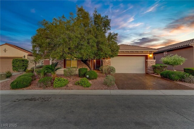 936 Viscanio Pl, Las Vegas, NV 89138 - view of front facade featuring driveway, stone siding, a tile roof, and an attached garage
