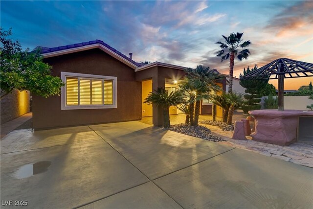 view of front of home with stucco siding and a patio