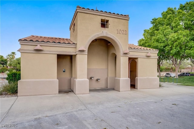 entrance to property with a tiled roof and stucco siding