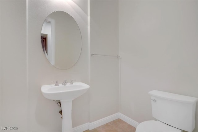 bathroom featuring toilet and baseboards