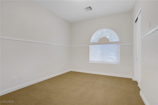 empty room featuring carpet and baseboards