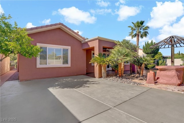 view of front of home with stucco siding and a patio