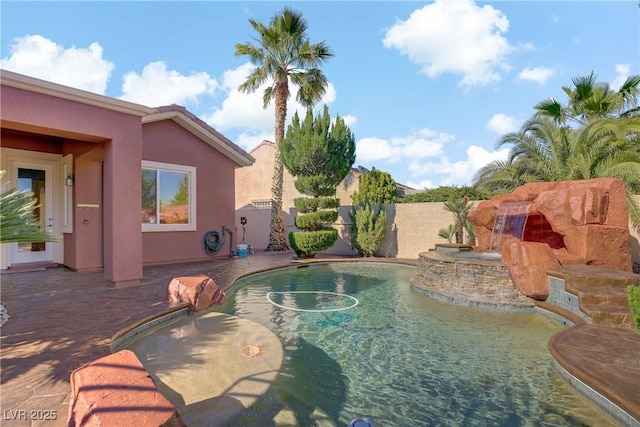 view of swimming pool with fence, a patio, and a pool with connected hot tub