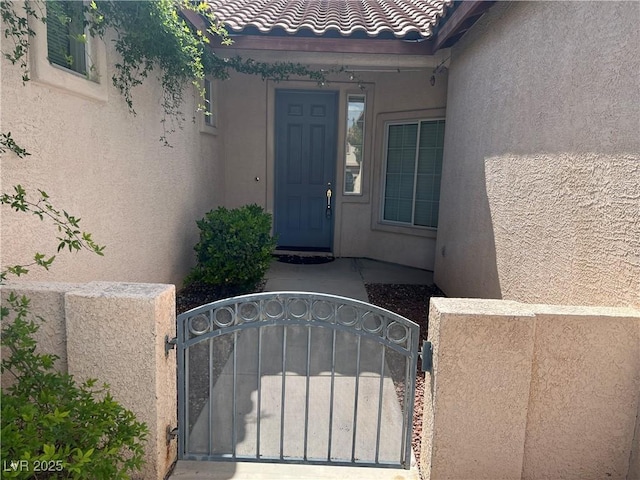 2855 Grande Valley Dr, Las Vegas, NV 89135 - property entrance with stucco siding, a gate, a tile roof, and fence