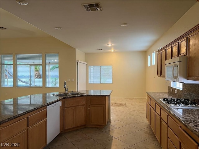 2855 Grande Valley Dr, Las Vegas, NV 89135 - kitchen with a sink, white appliances, light tile patterned floors, decorative backsplash, and dark stone countertops