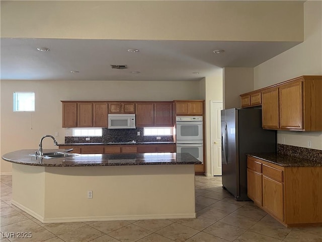 2855 Grande Valley Dr, Las Vegas, NV 89135 - kitchen with white appliances, a sink, a large island with sink, brown cabinets, and recessed lighting