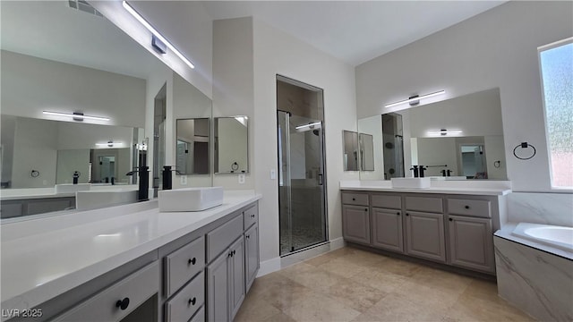 bathroom with a stall shower, healthy amount of natural light, a bath, and two vanities
