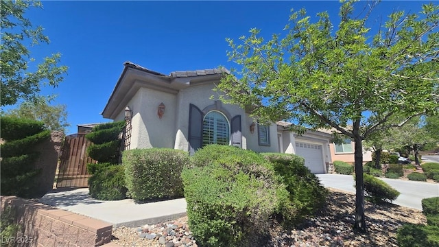mediterranean / spanish-style home featuring stucco siding, an attached garage, and concrete driveway