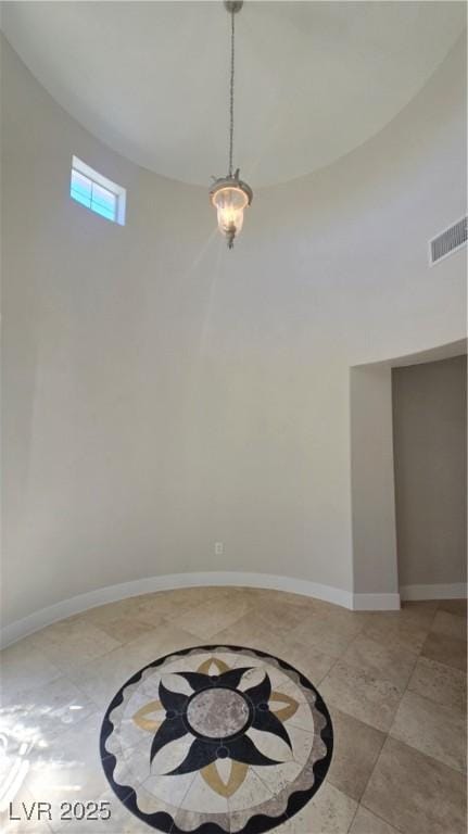 spare room with a towering ceiling and baseboards
