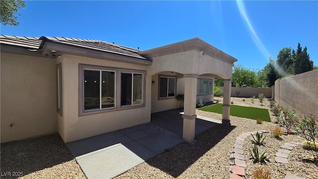 rear view of house featuring a fenced backyard, stucco siding, a patio area, and a tile roof