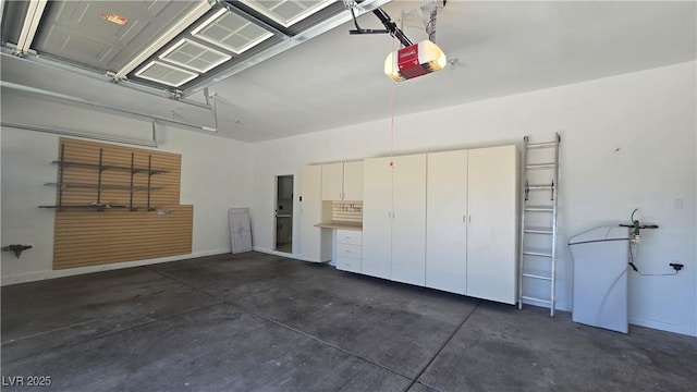 garage featuring a garage door opener and baseboards