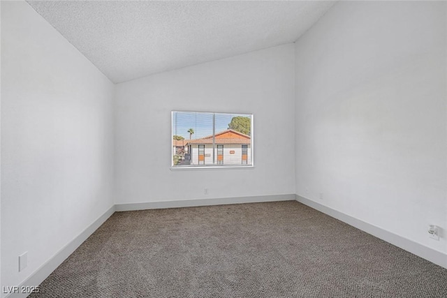 carpeted empty room with lofted ceiling, baseboards, and a textured ceiling