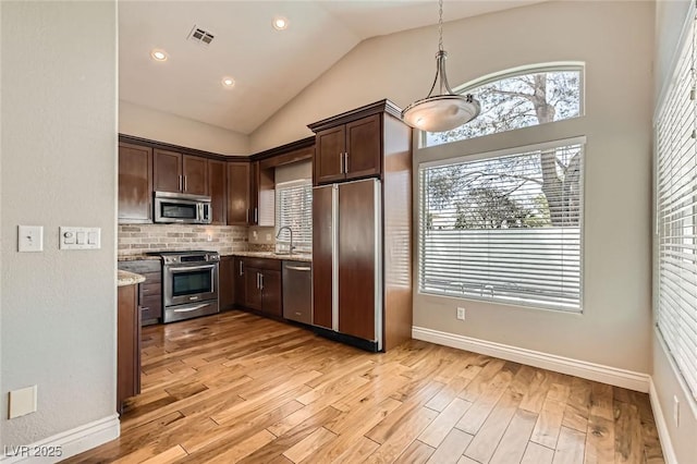 8124 Bay Harbor Dr, Las Vegas, NV 89128 - kitchen featuring stainless steel appliances, dark brown cabinets, a sink, light wood-style flooring, and vaulted ceiling