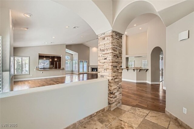 8124 Bay Harbor Dr, Las Vegas, NV 89128 - hallway featuring decorative columns, healthy amount of natural light, high vaulted ceiling, baseboards, and arched walkways